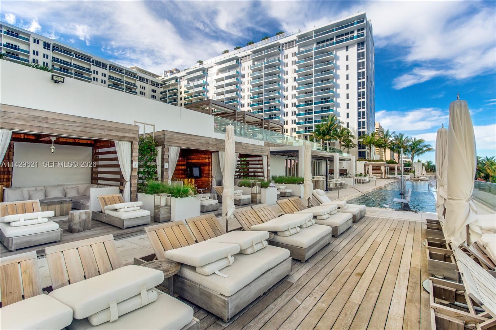 A bedroom features a mirrored headboard, white brick wall, and a gray chevron area rug — 102 24th St # 1108, Miami Beach FL 33139, MIAMI BEACH, FL
