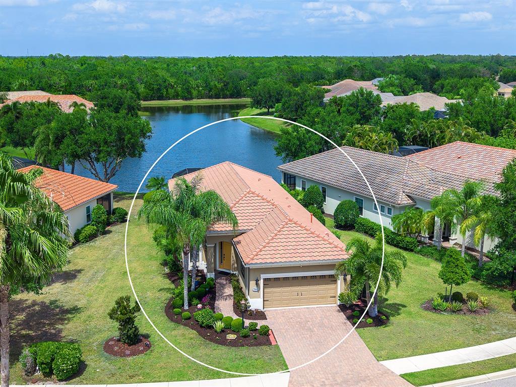 An aerial view shows a single-story house with a tiled roof and a paved driveway — 7263 BELLEISLE GLEN, LAKEWOOD RANCH, FL