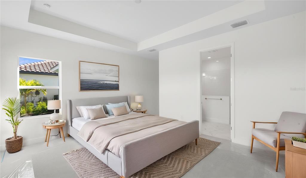 A modern bedroom features a gray upholstered bed, white walls, tile floors, and an ensuite bathroom — 13411 HERITAGE PRESERVE DRIVE, FORT MYERS, FL