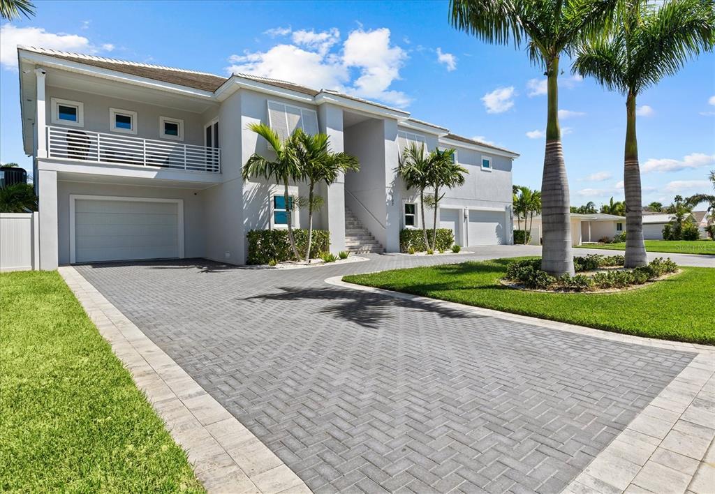 A two-story house with a paved driveway, palm trees, and a second-floor balcony — 107 12TH STREET, BELLEAIR BEACH, FL