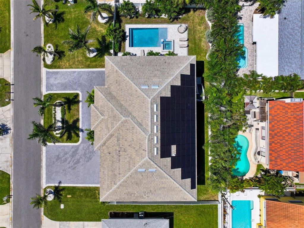 An aerial view shows a house with a solar panel array on its roof — 107 12TH STREET, BELLEAIR BEACH, FL
