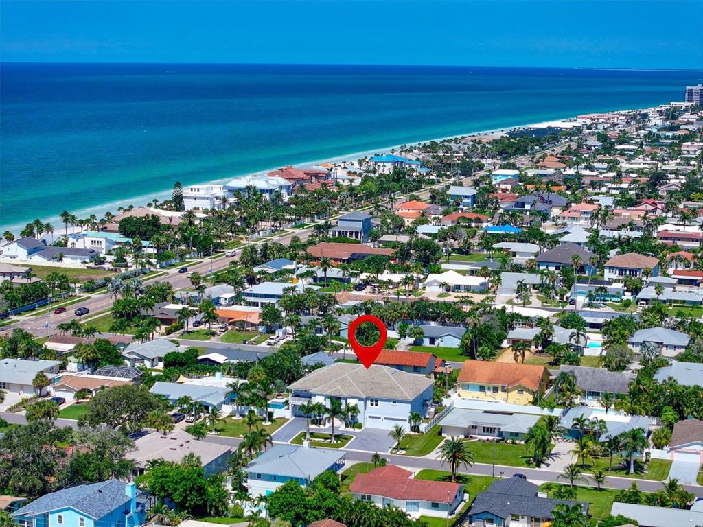An aerial view shows a residential neighborhood near the ocean with a red location pin — 107 12TH STREET, BELLEAIR BEACH, FL