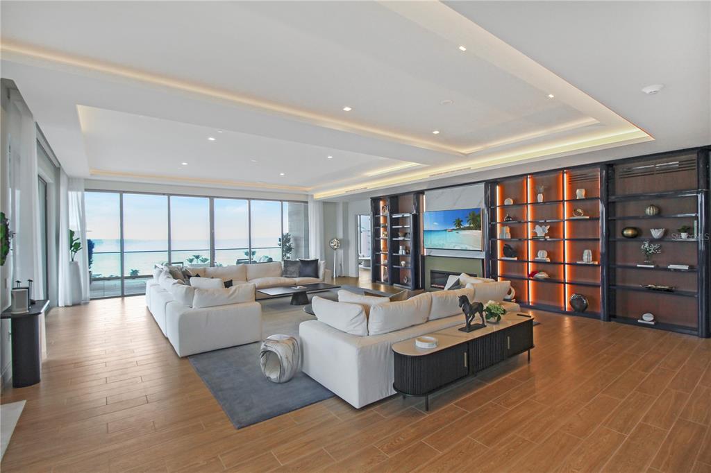 A modern multi-story apartment building features stacked balconies with glass railings and stone facade accents — 1591 GULF OF MEXICO DRIVE UNIT 619, LONGBOAT KEY, FL