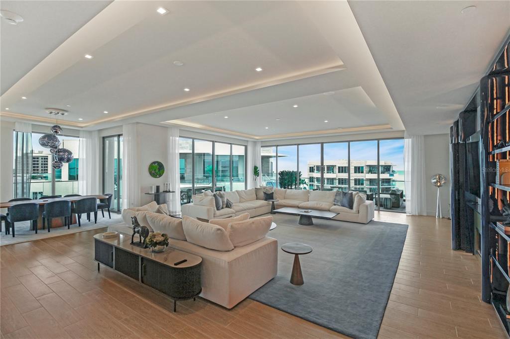 A spacious living room features a large sectional sofa, a fireplace, and floor-to-ceiling windows — 1591 GULF OF MEXICO DRIVE UNIT 619, LONGBOAT KEY, FL