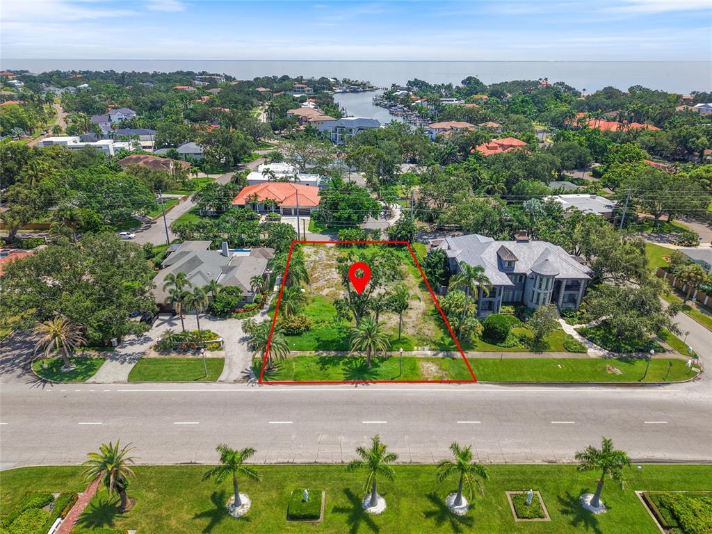 An aerial view shows a vacant residential lot outlined in red between two houses — 409 SNELL ISLE BOULEVARD NE, ST PETERSBURG, FL