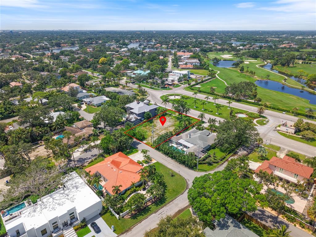 An aerial view shows a vacant, rectangular lot outlined in red within a residential neighborhood — 409 SNELL ISLE BOULEVARD NE, ST PETERSBURG, FL