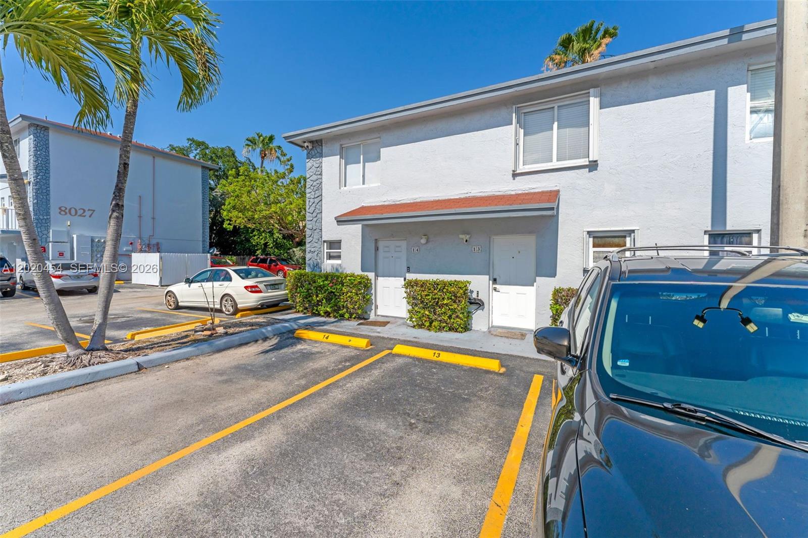An exterior view of a two-story apartment building with designated parking spaces in front — 8025 NW 8th St # 13, Miami FL 33126, MIAMI, FL