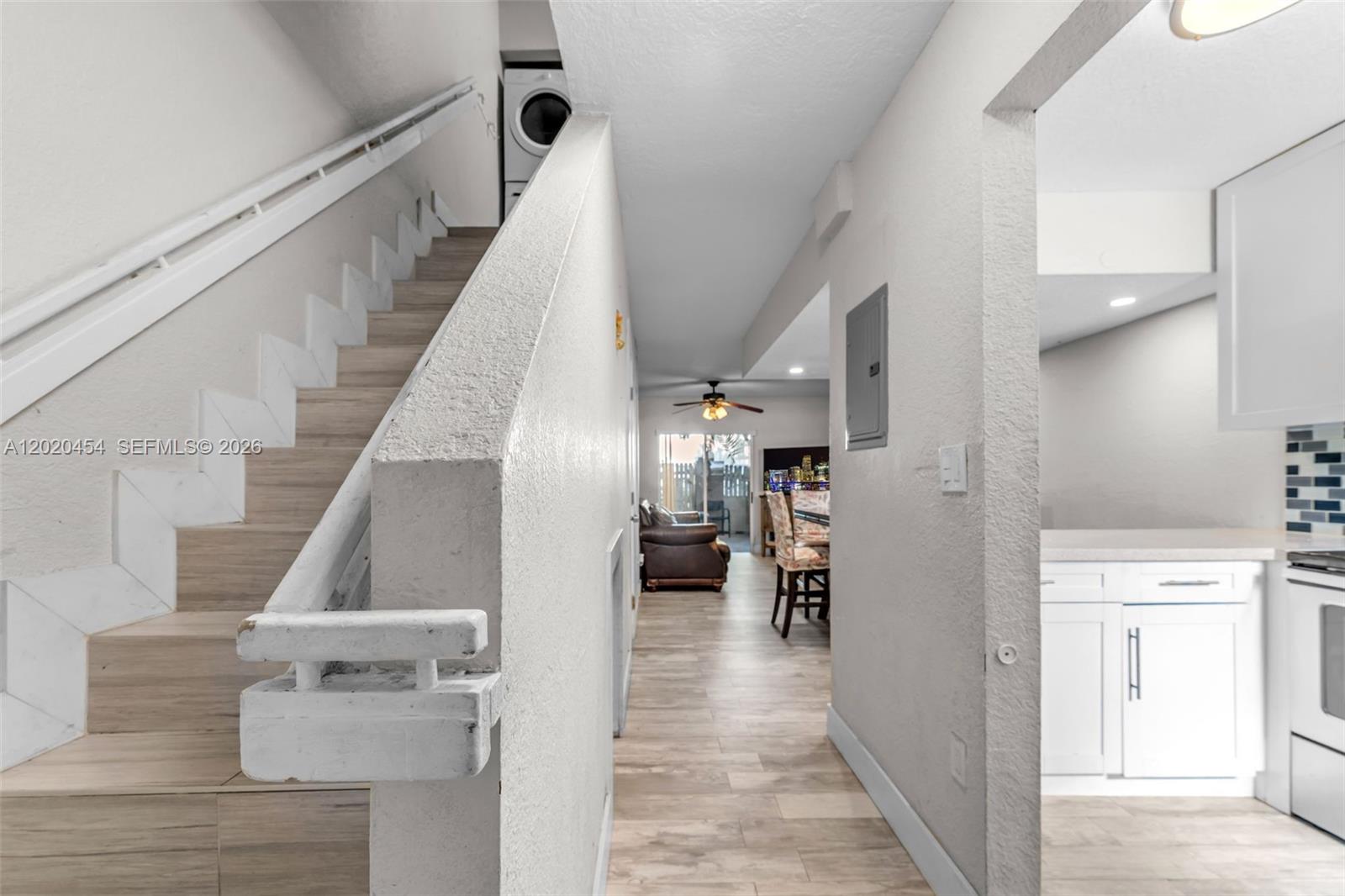 A hallway leads from a staircase toward a living area with a kitchen on the right — 8025 NW 8th St # 13, Miami FL 33126, MIAMI, FL