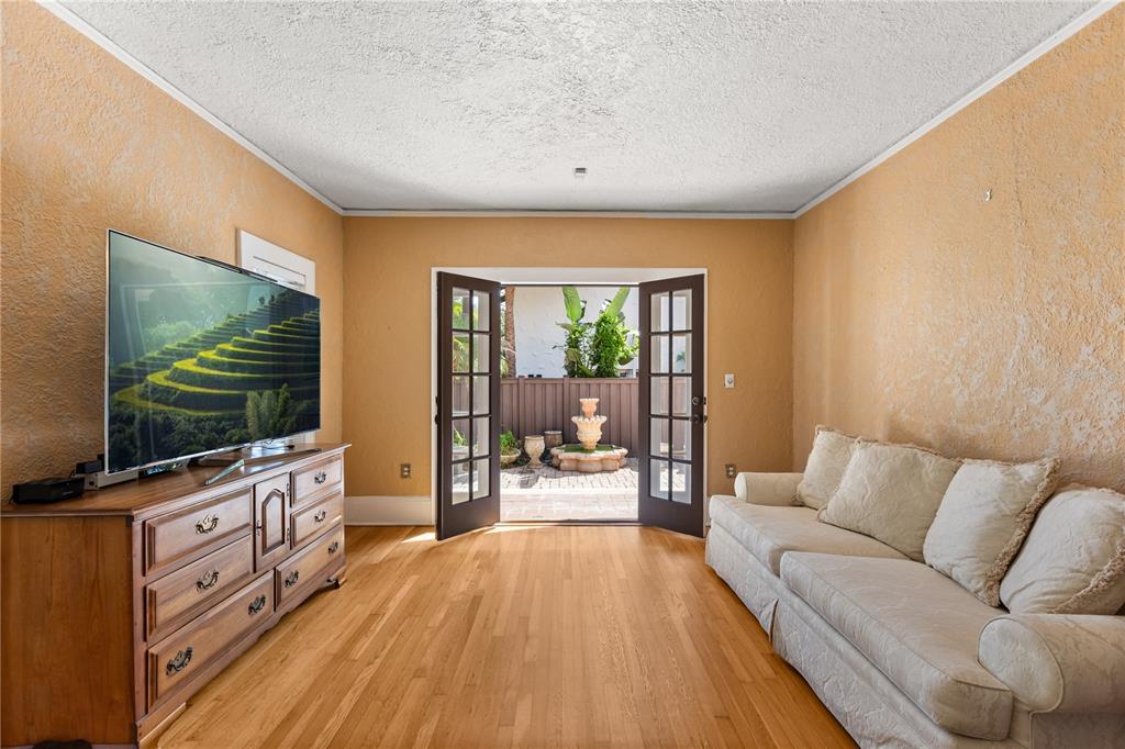 A living room with hardwood floors, a beige sofa, and French doors opening to a patio — 737 SPRINGDALE RD, ORLANDO, FL