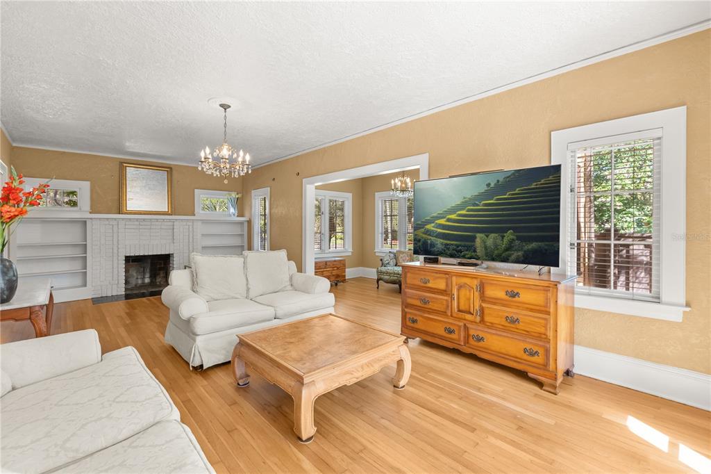 A living room features hardwood floors, a white fireplace, and a television on a wooden dresser — 737 SPRINGDALE RD, ORLANDO, FL