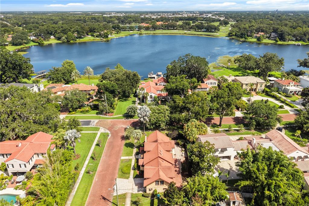 An aerial view shows several houses with red-tiled roofs situated along a large lake — 737 SPRINGDALE RD, ORLANDO, FL