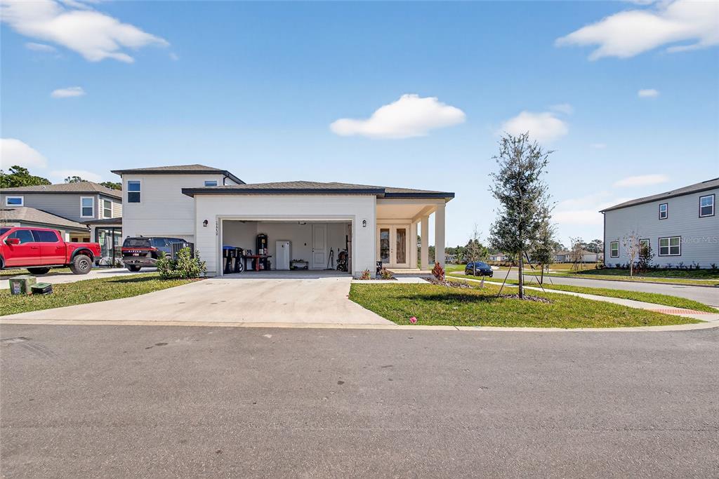 A single-story house with a white exterior, a two-car garage, and a covered front porch — 17739 SHARP PUMMELO ALLEY, WINTER GARDEN, FL