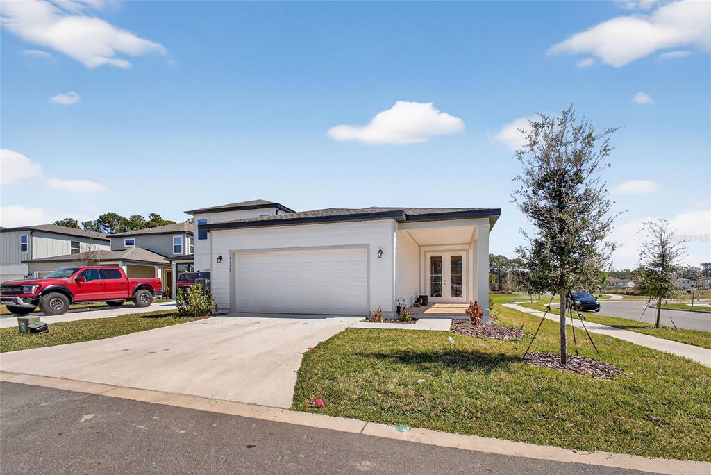 A single-story house with a white exterior, a two-car garage, and a front entryway — 17739 SHARP PUMMELO ALLEY, WINTER GARDEN, FL