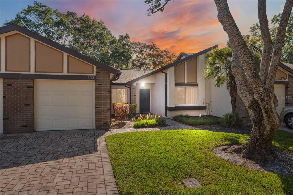 A single-story house with a brick and stucco exterior, a paved driveway, and a front lawn — 7522 HEATHER WALK DRIVE, WEEKI WACHEE, FL