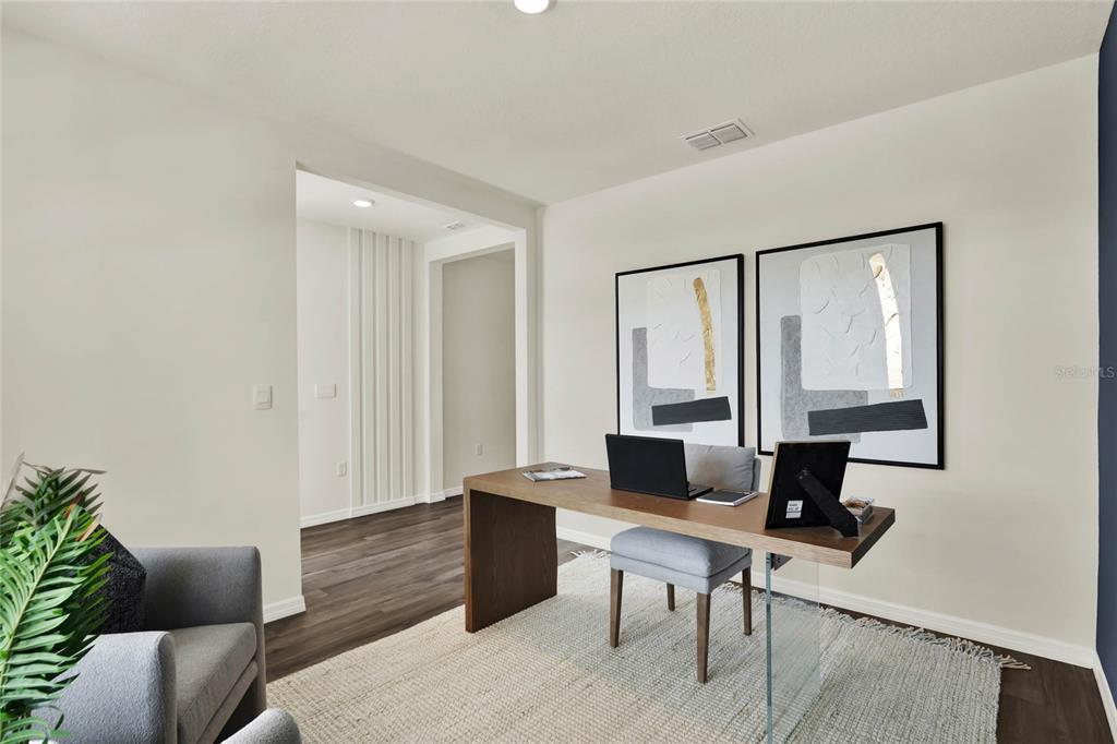 A home office features a wooden desk, a grey chair, and two framed abstract prints — 5150 MARSHELDER STREET, APOPKA, FL