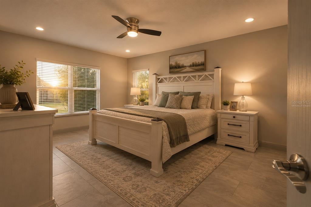 A bedroom features a white bed frame, a patterned area rug, and a ceiling fan — 5328 BALDOCK AVENUE, SPRING HILL, FL