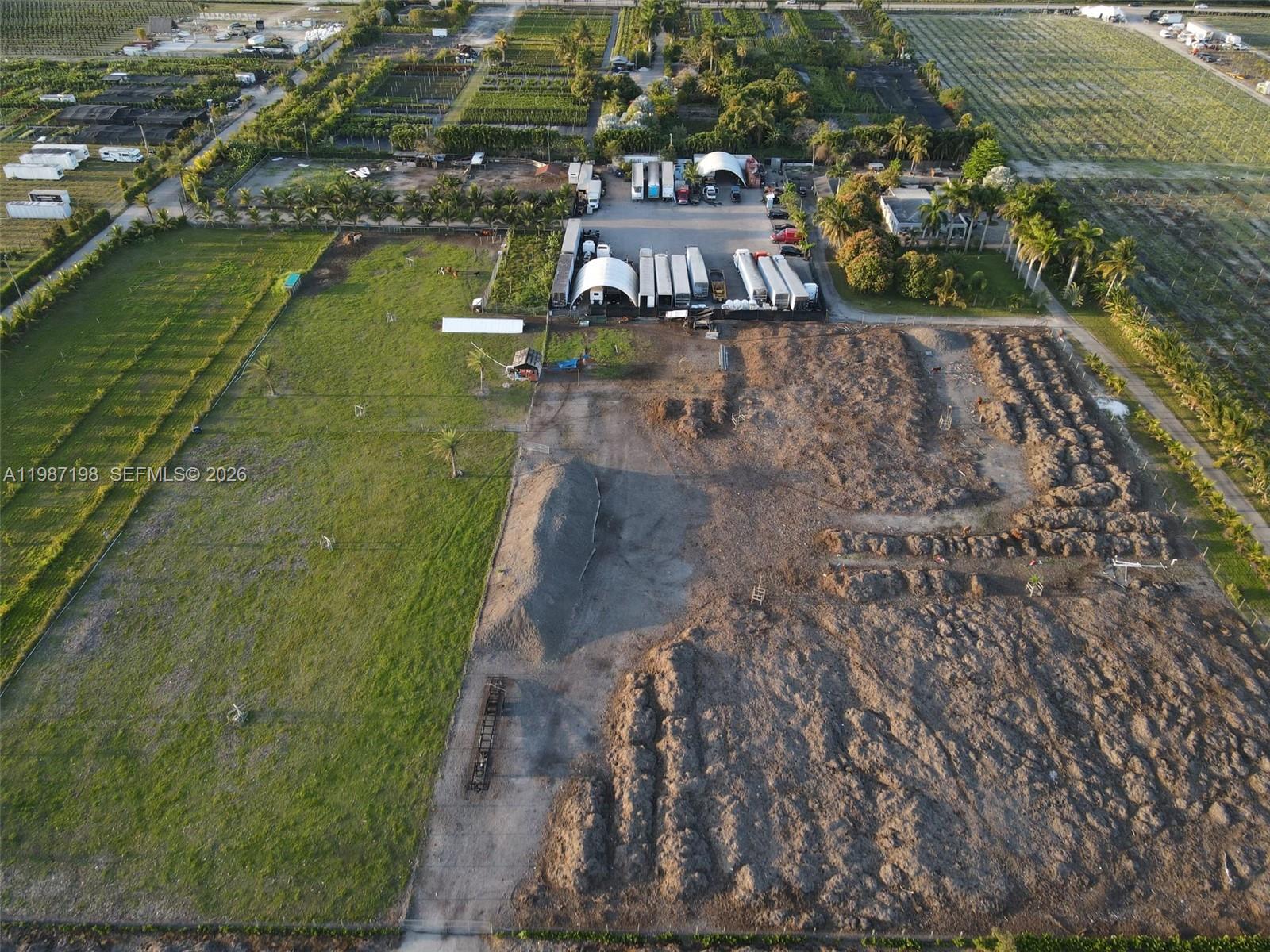 An aerial view shows a large rural property with a grassy field, dirt lot, and trailers — 17325 SW 188th St, Miami FL 33187, MIAMI, FL