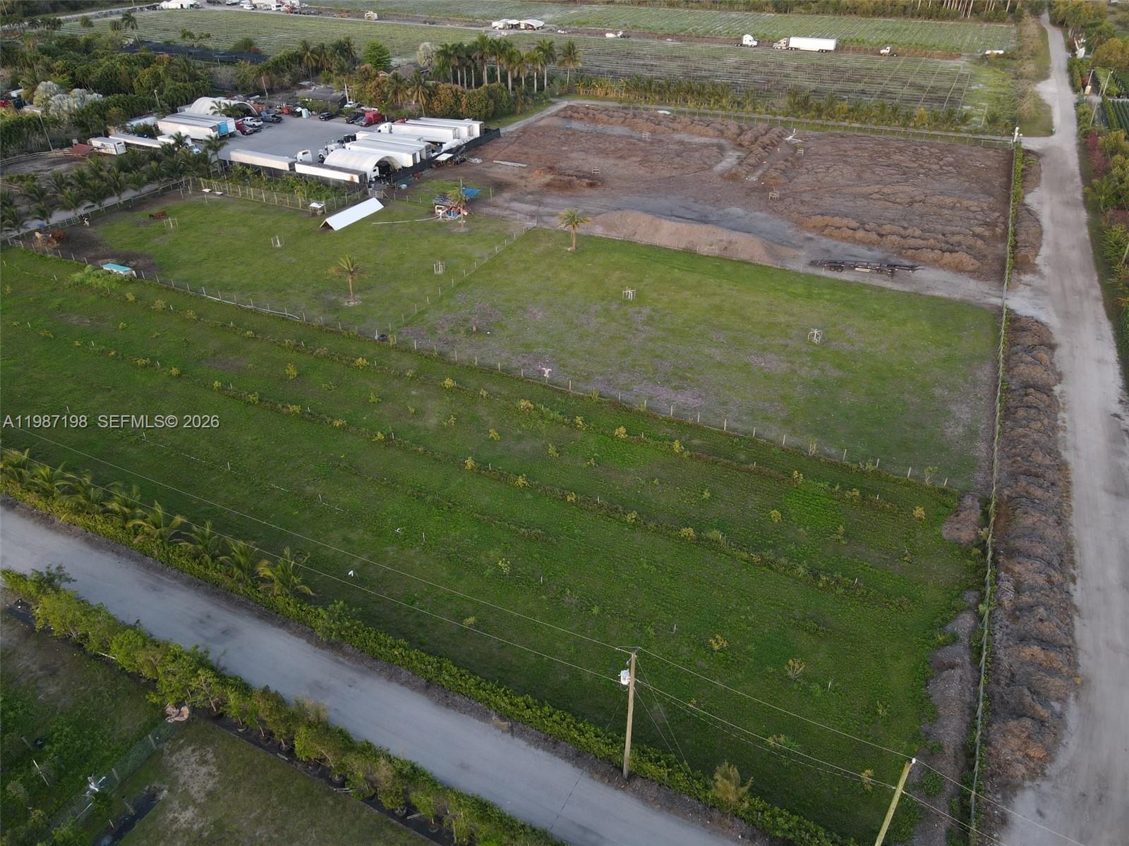 An aerial view shows a large, fenced plot of land with grass and dirt sections — 17325 SW 188th St, Miami FL 33187, MIAMI, FL