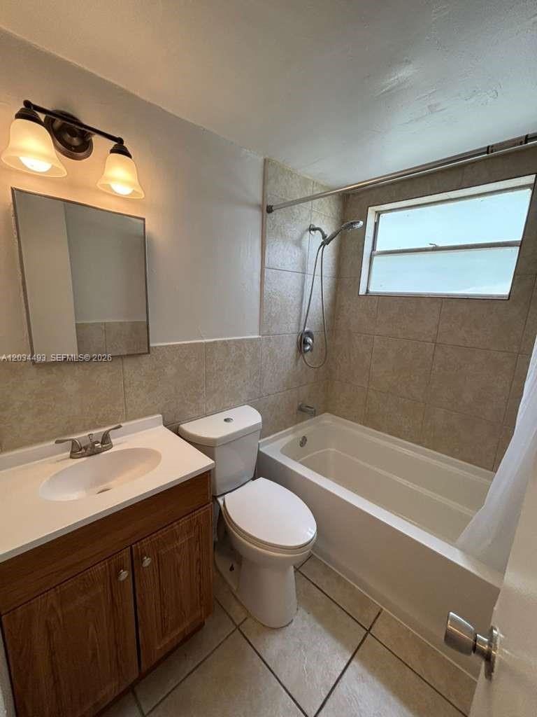 A bathroom features a vanity, toilet, and a tiled shower-tub combination with a window — 14120 NW 24th Ct # 204, Opa-Locka FL 33054, OPA-LOCKA, FL