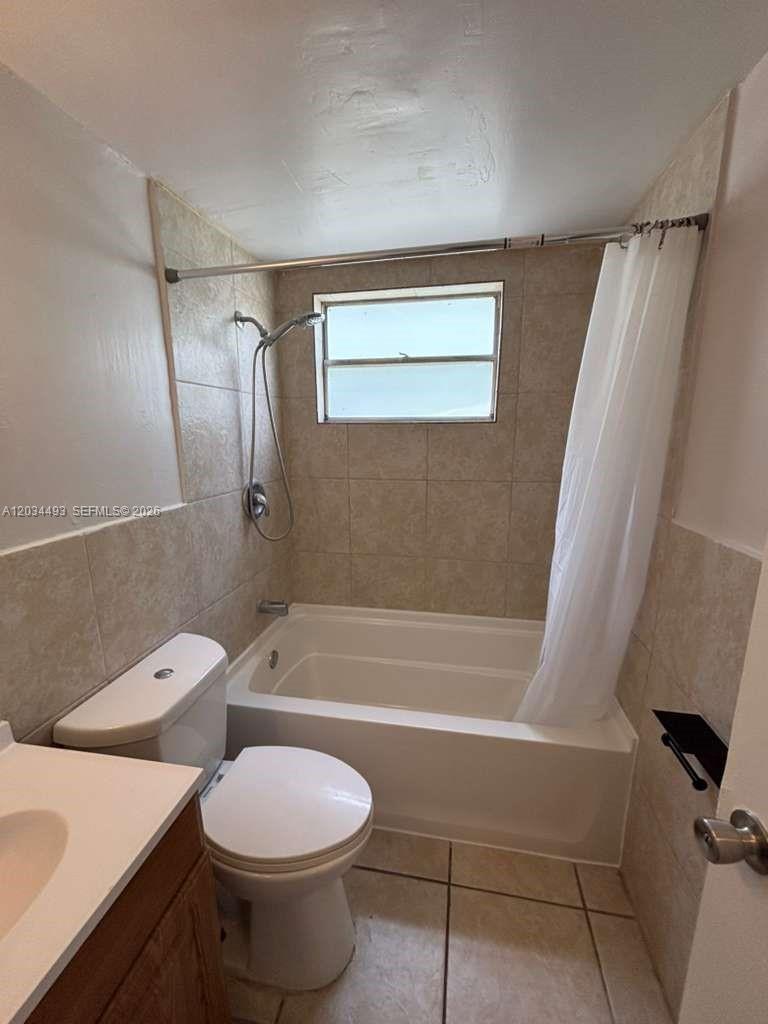 A bathroom features a tiled shower-tub combination, a white toilet, and a vanity — 14120 NW 24th Ct # 204, Opa-Locka FL 33054, OPA-LOCKA, FL