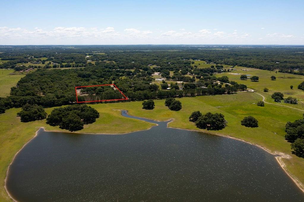 An aerial view shows a rectangular plot of land outlined in red near a lake — 0 MILLER ROAD, DADE CITY, FL