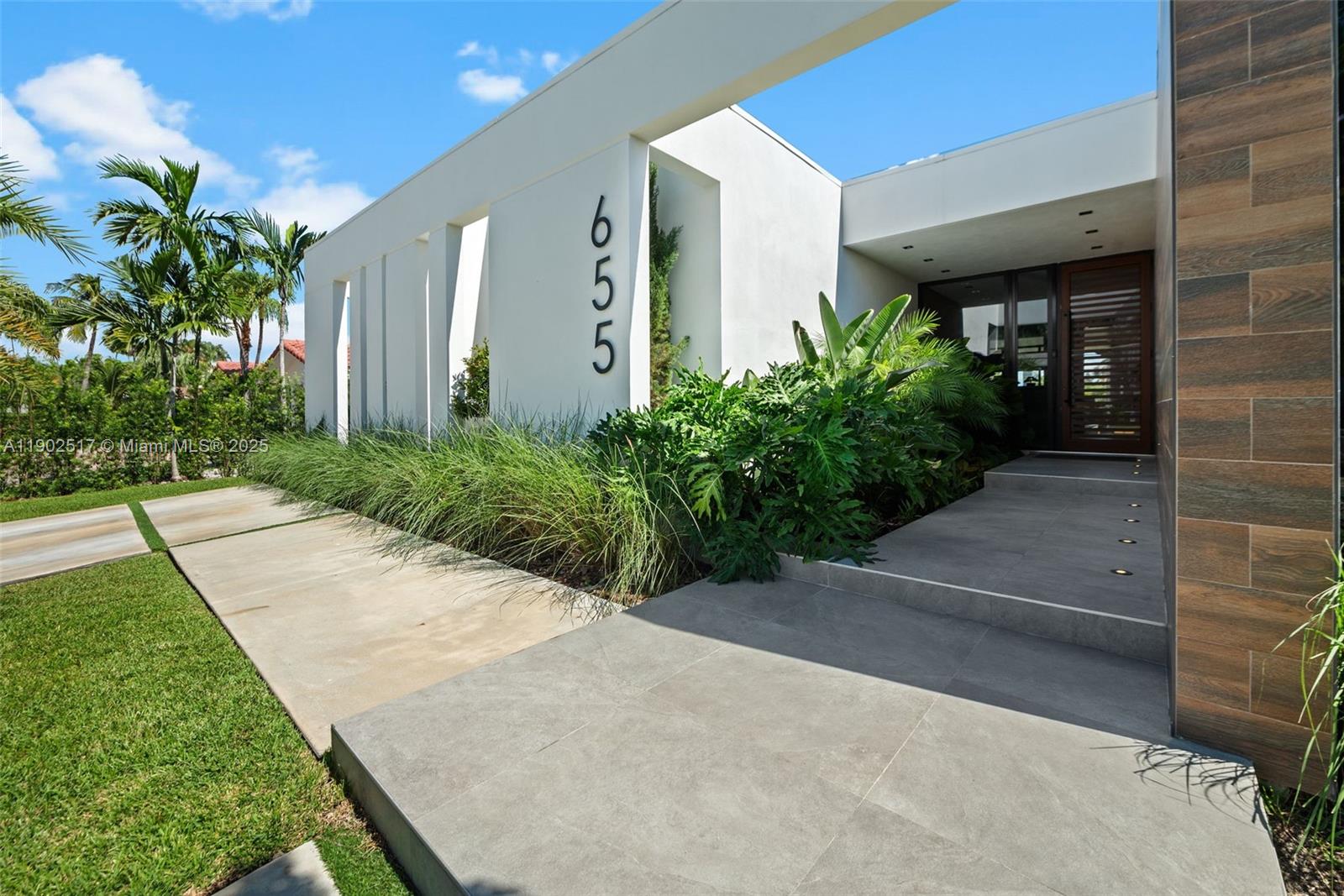 A modern house exterior features a white facade with the number 655 and tiled walkway — 655 Layne Blvd # 0, Hallandale Beach FL 33009, HALLANDALE BEACH, FL