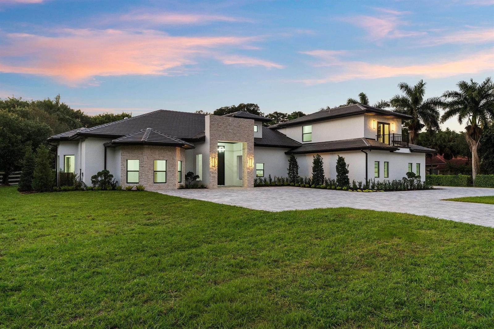 A two-story house with a stone entryway, dark tile roof, and a large paver driveway — 6451 Rodeo Drive, Southwest Ranches FL 33330, SOUTHWEST RANCHES, FL