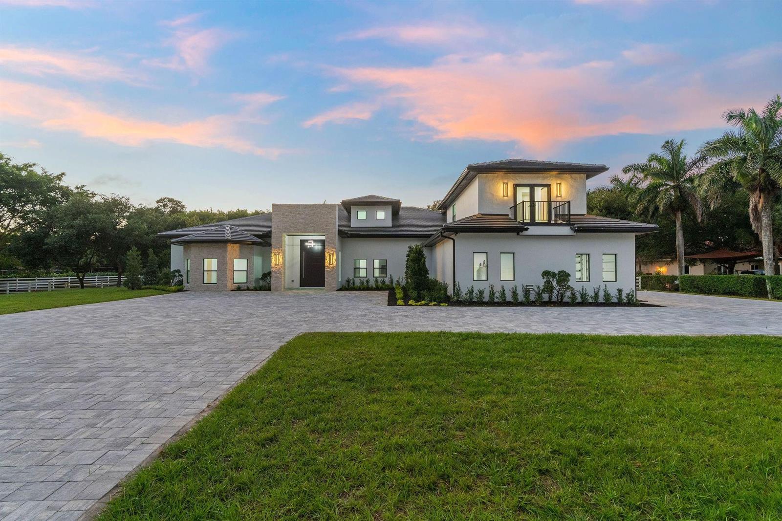 A modern two-story house with a stone entryway, dark tile roof, and a paved driveway — 6451 Rodeo Drive, Southwest Ranches FL 33330, SOUTHWEST RANCHES, FL