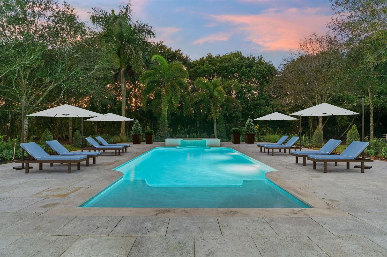 A modern home entrance features stone pillars, vertical wall sconces, and a large glass door — 6451 Rodeo Drive, Southwest Ranches FL 33330, SOUTHWEST RANCHES, FL