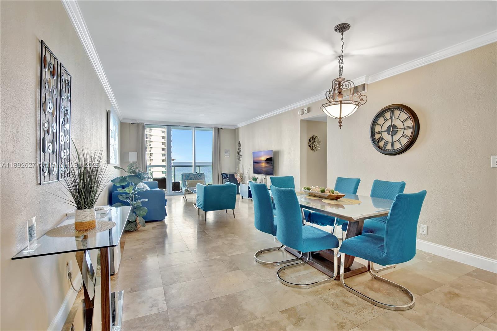 A dining area and living room with blue furniture, tile floors, and ocean views — 3801 S Ocean Dr # 6Z, Hollywood FL 33019, HOLLYWOOD, FL