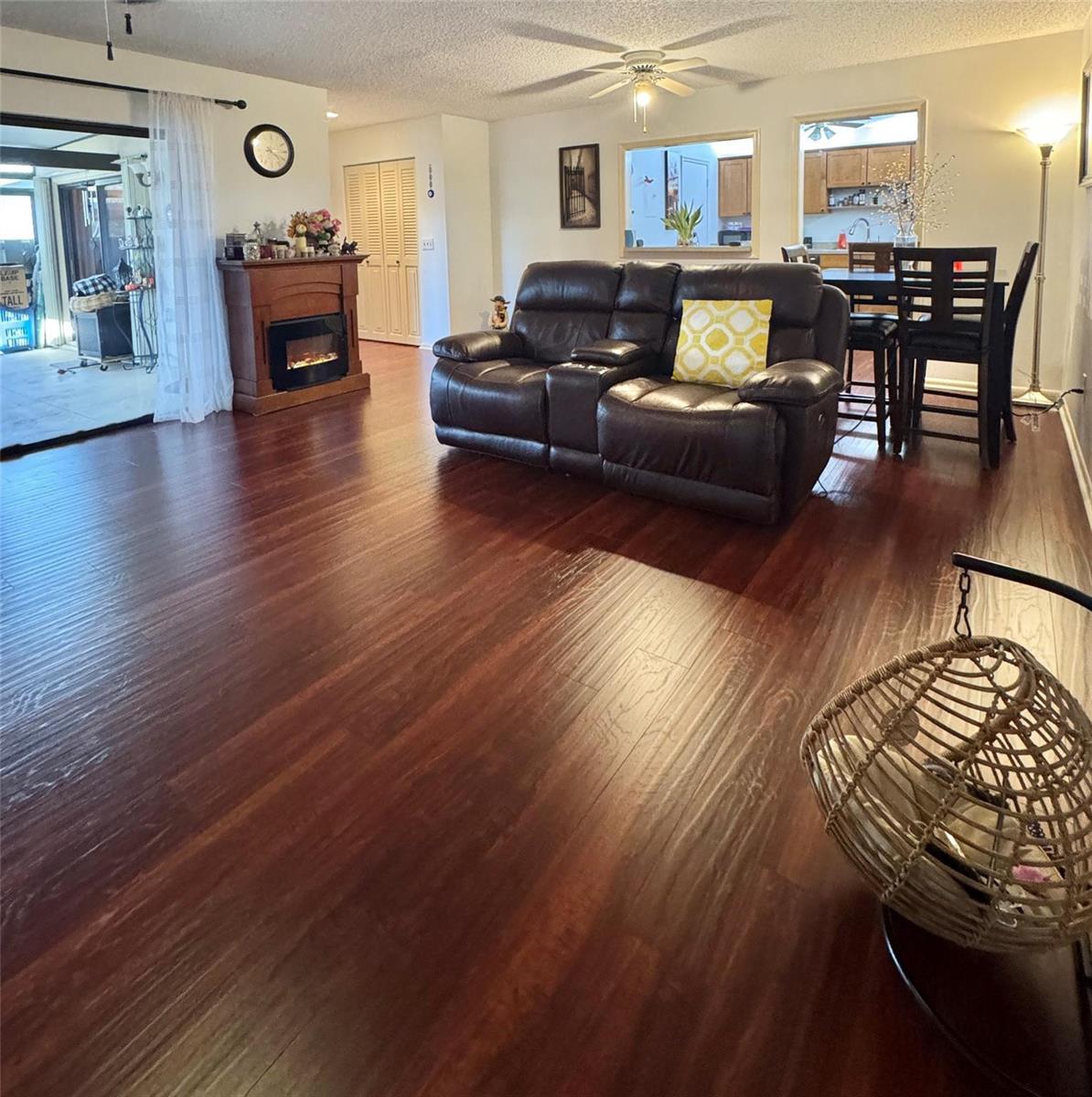 A living room with dark wood flooring, a leather loveseat, and a fireplace — 8090 Ambach Way # B, Hypoluxo FL 33462, HYPOLUXO, FL