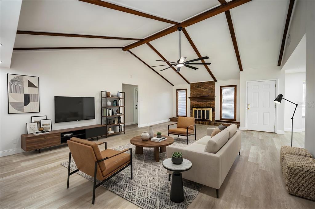 A living room features vaulted ceilings with exposed beams, a brick fireplace, and modern furniture — 4090 OLD COLONY ROAD, MULBERRY, FL