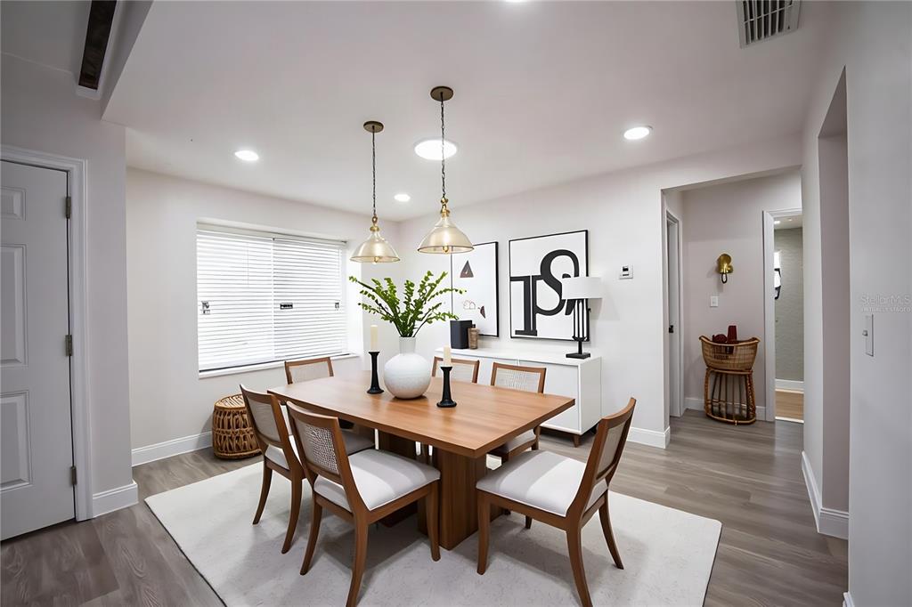 A dining room features a wooden table, six chairs, two pendant lights, and white walls — 4090 OLD COLONY ROAD, MULBERRY, FL