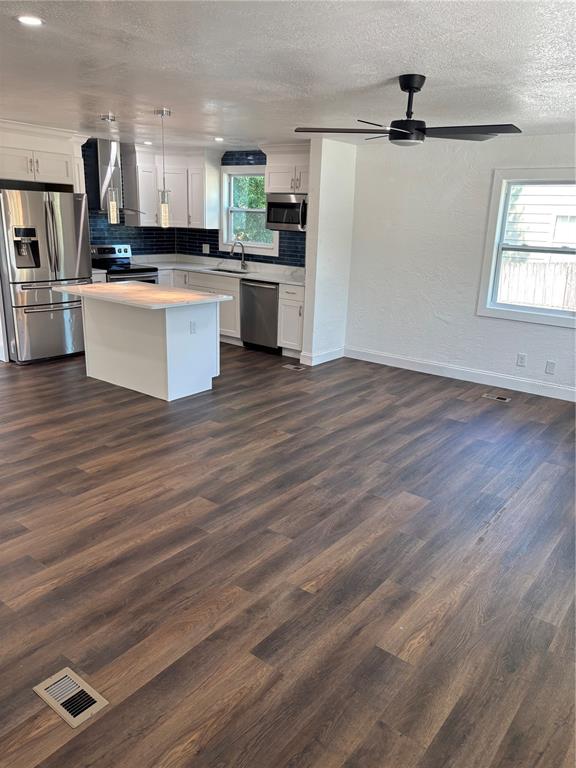 A kitchen features white cabinetry, a marble-patterned island, stainless steel appliances, and blue tile backsplash — 4420 6TH AVENUE S, ST PETERSBURG, FL