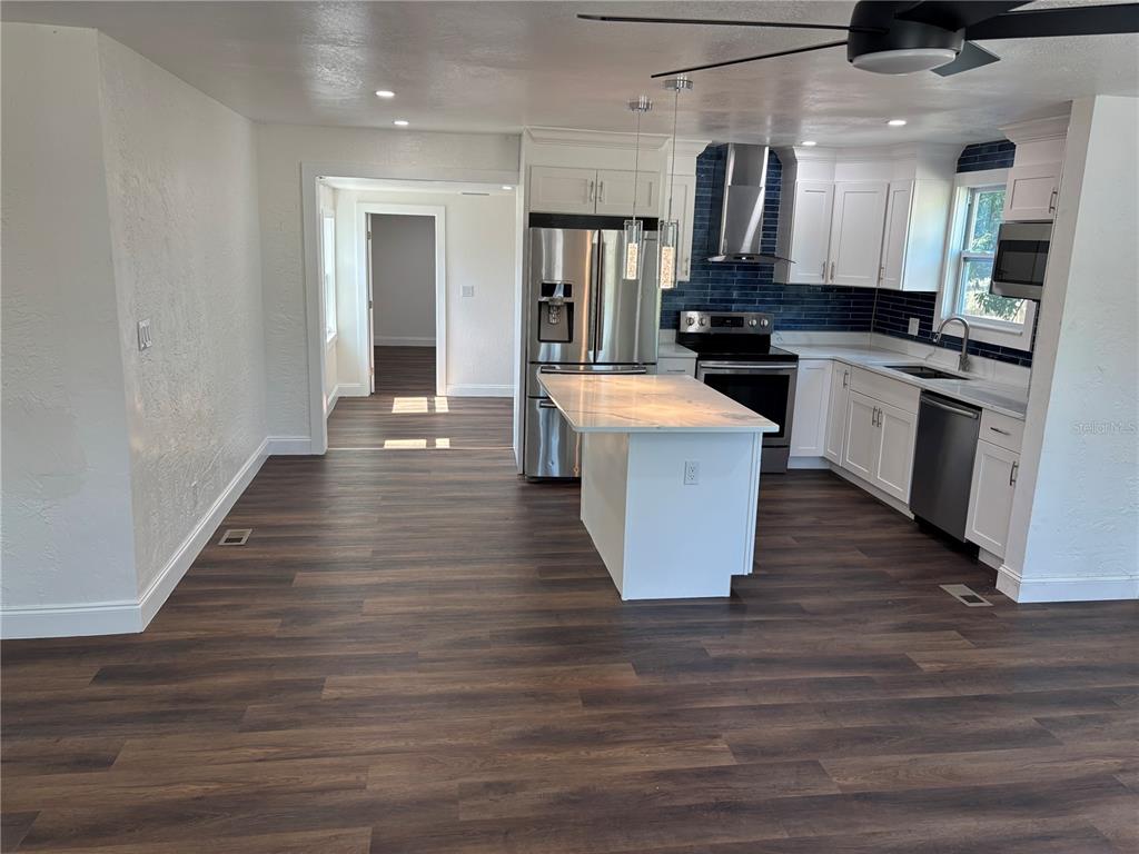 A kitchen features white cabinets, a stainless steel stove, and a blue subway tile backsplash — 4420 6TH AVENUE S, ST PETERSBURG, FL