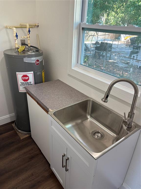 A bathroom features a white tub with marble-look tile walls, a toilet, and a vanity — 4420 6TH AVENUE S, ST PETERSBURG, FL