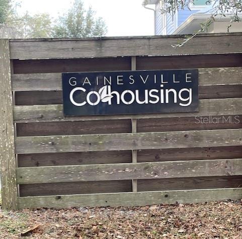 A wooden fence displays a sign for Gainesville Cohousing — 2660 NW 47TH TERRACE, GAINESVILLE, FL