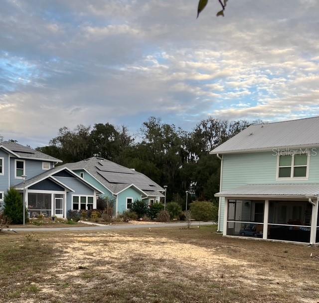 A view of several houses with screened-in porches and solar panels under a cloudy sky — 2660 NW 47TH TERRACE, GAINESVILLE, FL