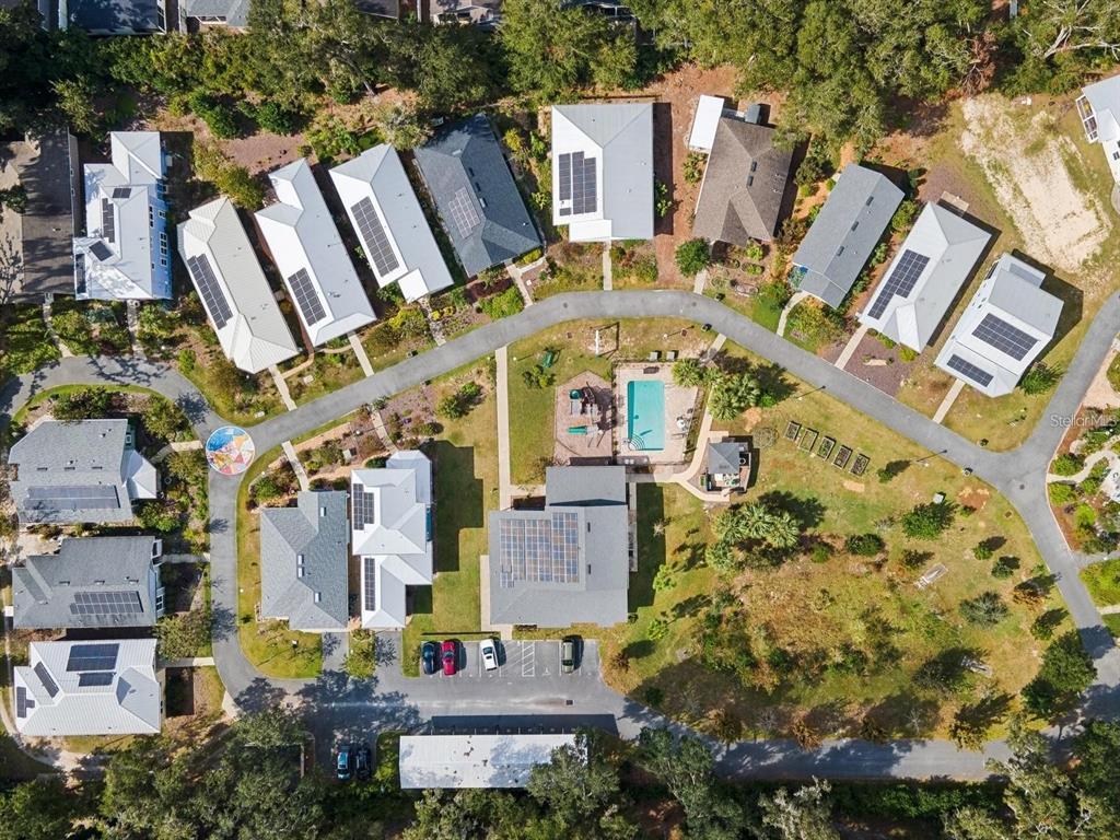 This aerial view shows a residential neighborhood with houses, a community pool, and parking areas — 2660 NW 47TH TERRACE, GAINESVILLE, FL