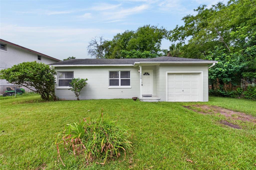 A single-story house with light green siding, a white front door, and an attached garage — 126 HARNEY STREET, DAYTONA BEACH, FL
