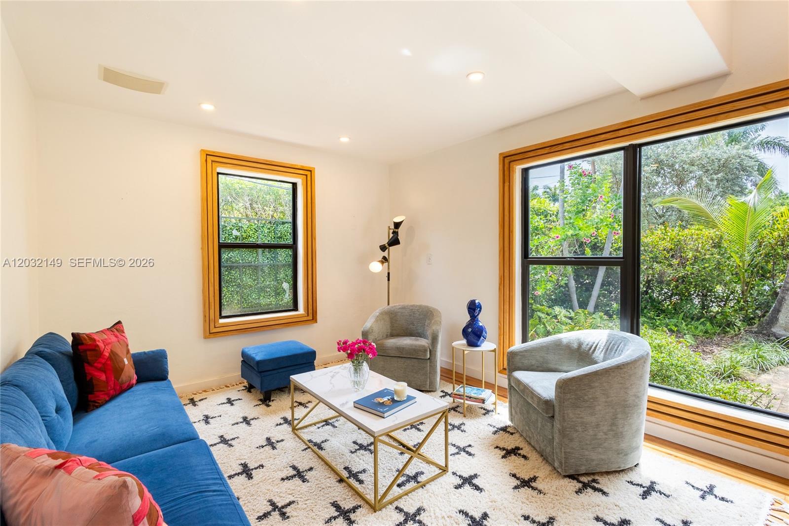 A living room features a blue sofa, two gray armchairs, and a patterned area rug — 4230 Royal Palm Ave, Miami Beach FL 33140, MIAMI BEACH, FL