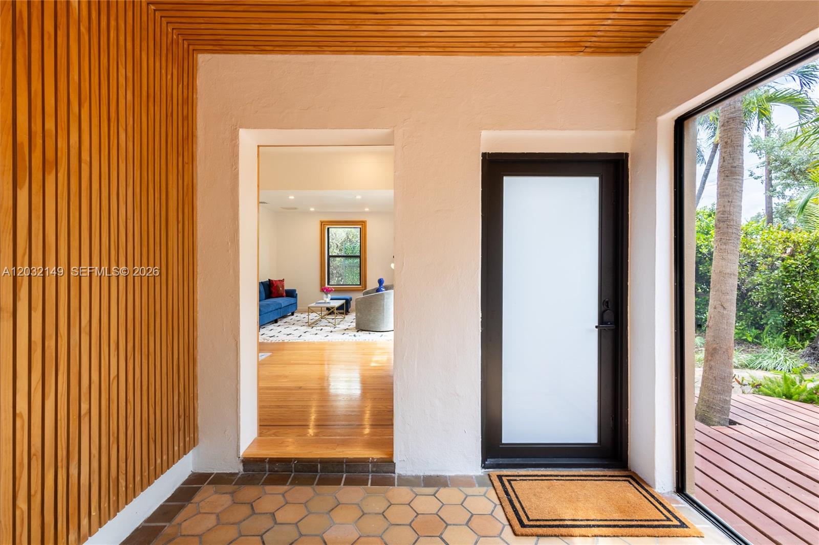 An entryway features a slatted wood ceiling and wall, hexagonal floor tiles, and a glass door — 4230 Royal Palm Ave, Miami Beach FL 33140, MIAMI BEACH, FL