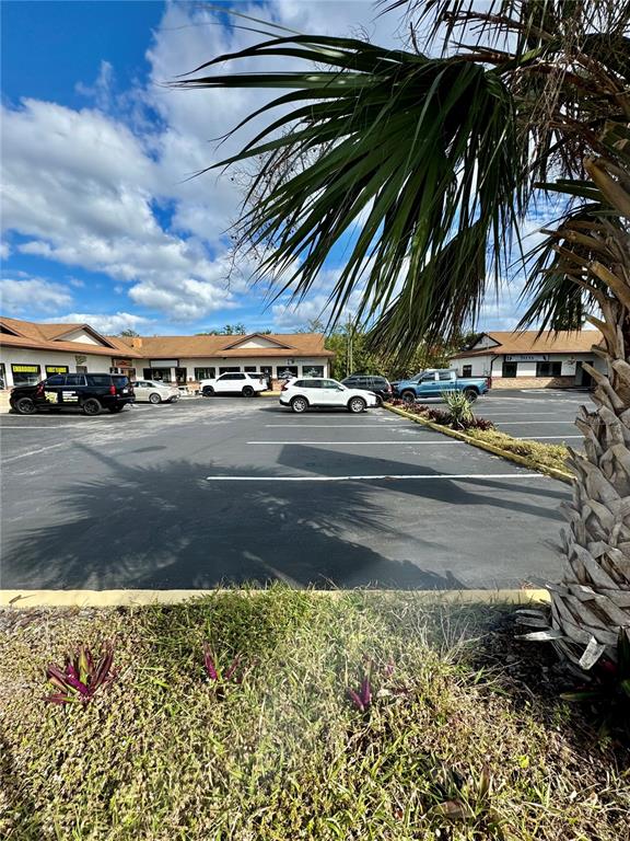 A parking lot sits in front of a commercial strip mall under a blue sky — 2335 S RIDGEWOOD AVENUE, SOUTH DAYTONA, FL