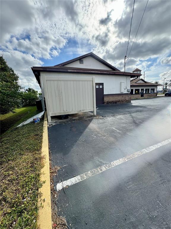 The exterior of a commercial building features a privacy fence and an adjacent parking lot — 2335 S RIDGEWOOD AVENUE, SOUTH DAYTONA, FL