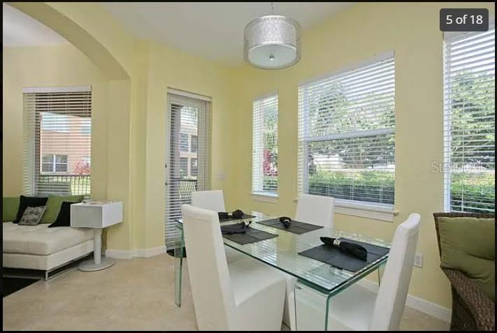 A living room with white tile floors, a white sectional sofa, and a sliding glass door — 5514 46TH COURT W, BRADENTON, FL