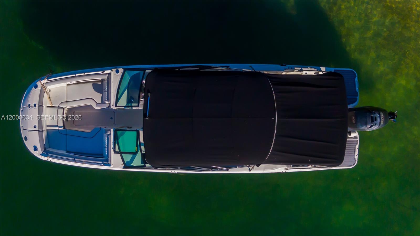 An aerial view shows a white motorboat with a black canopy floating on green water — 910 West Ave, Miami Beach FL 33139, MIAMI BEACH, FL