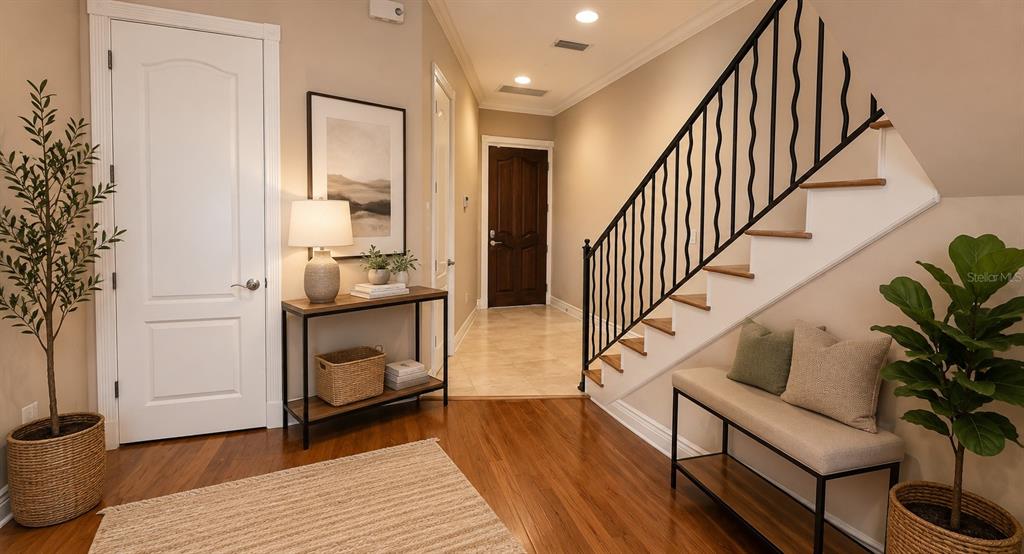 A foyer features hardwood floors, a staircase with a black railing, and a console table — 4907 BAYSHORE BOULEVARD UNIT 103, TAMPA, FL