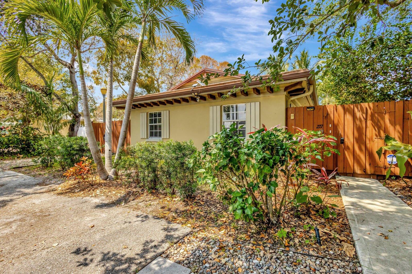 A single-story house with a tan exterior, white-trimmed windows, and a wooden privacy fence — 227 NE 12th Street # 1, Delray Beach FL 33444, DELRAY BEACH, FL