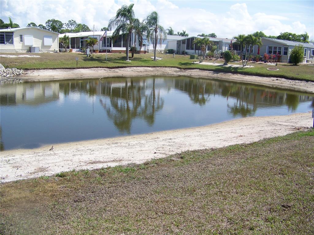A small pond sits in front of several manufactured homes with palm trees — 15550 BURNT STORE ROAD UNIT 101, PUNTA GORDA, FL