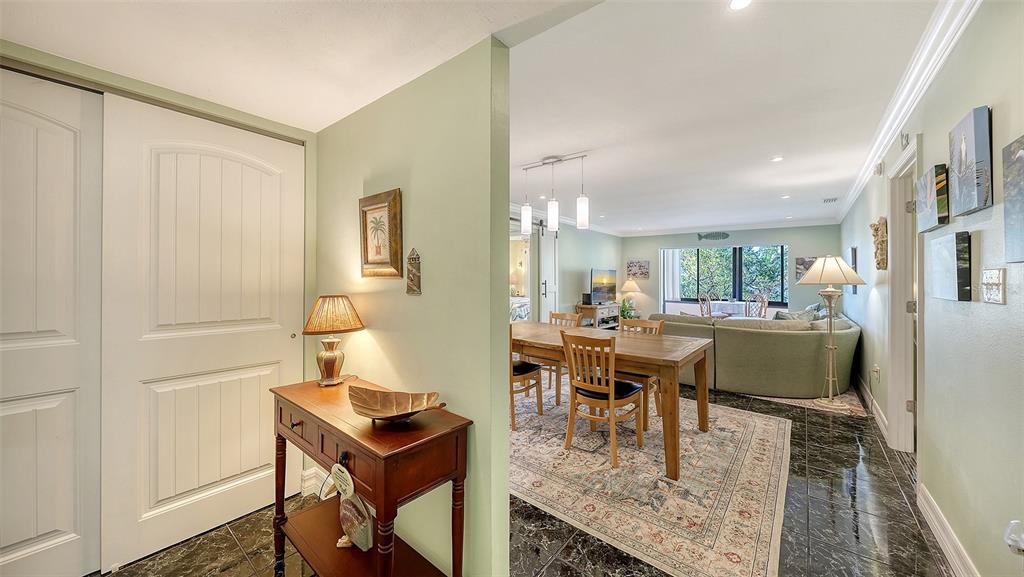A view from a hallway into a dining area and living room with tile floors — 1200 EAST PEPPERTREE LANE UNIT 302, SARASOTA, FL